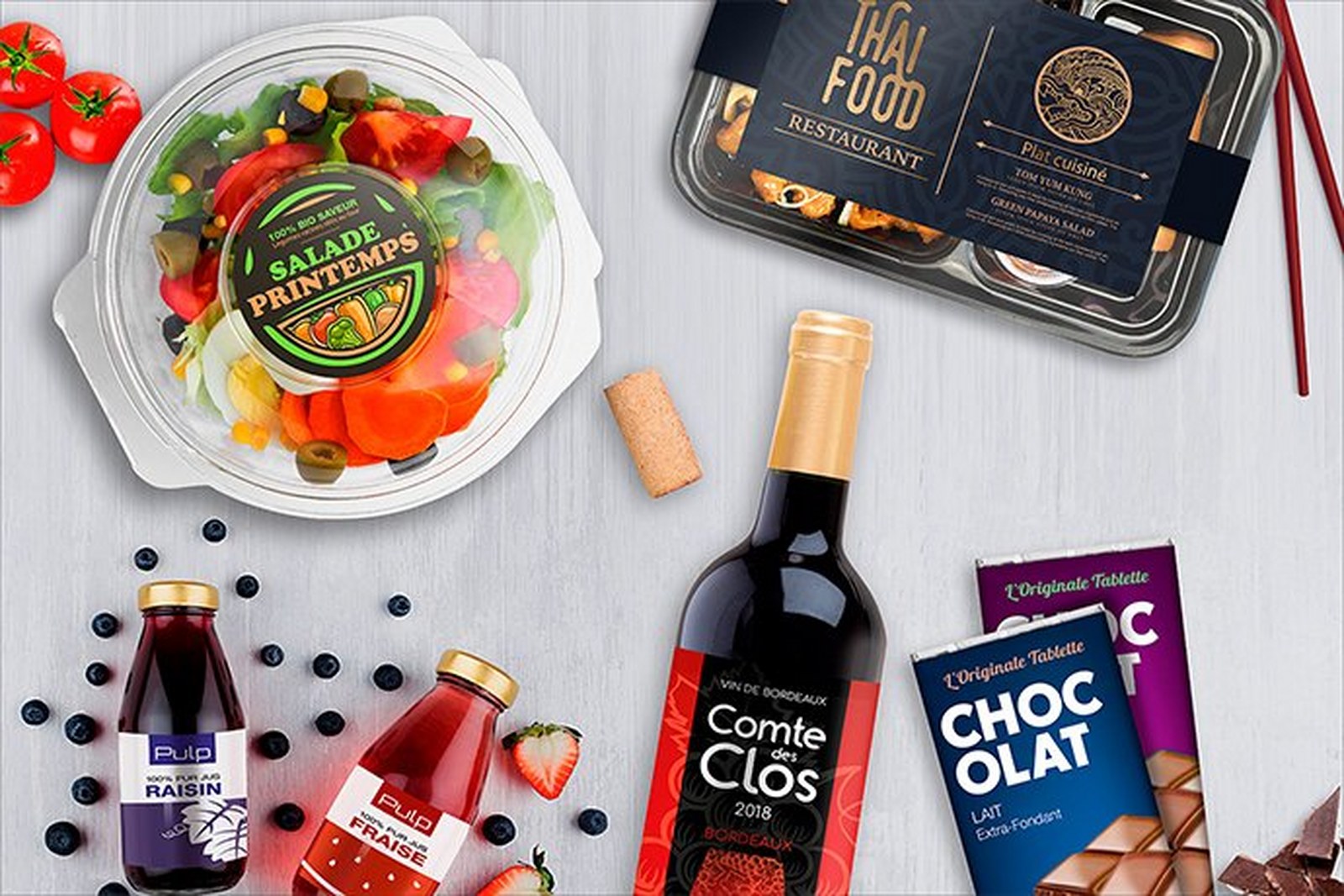 Produkty spożywcze — wino, sos, czekolada, sałatka w opakowaniu — z kolorowymi etykietami wydrukowanymi na drukarce Epson ColorWorks