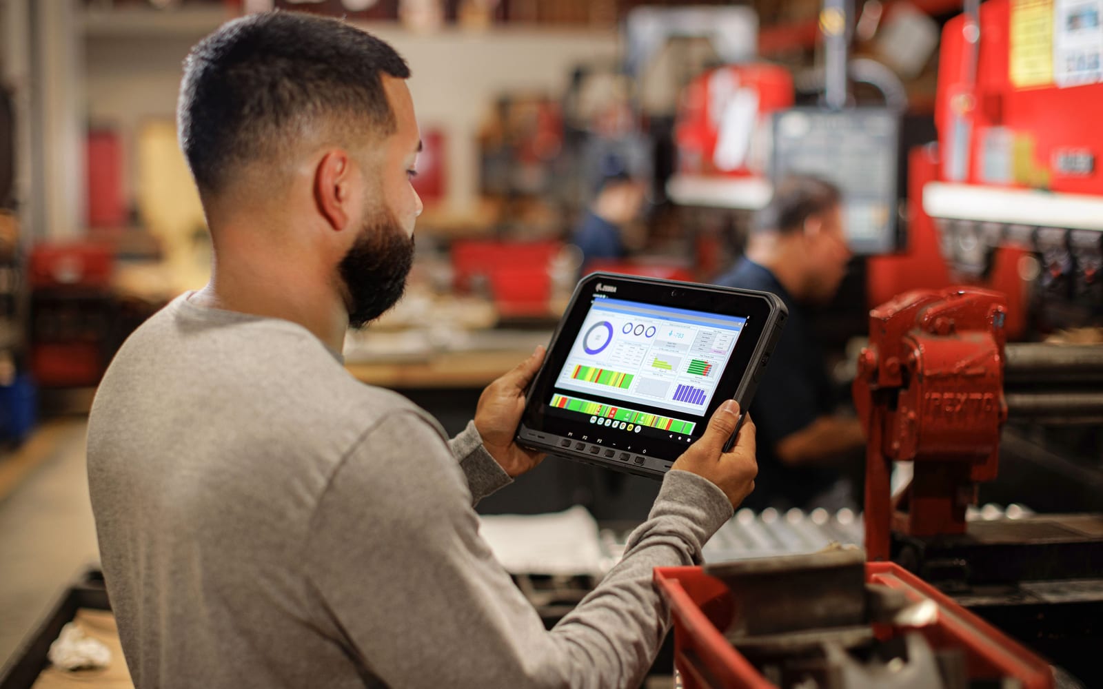 Technik w hali serwisowej przegląda dashboard utrzymania ruchu na tablecie Zebra ET60