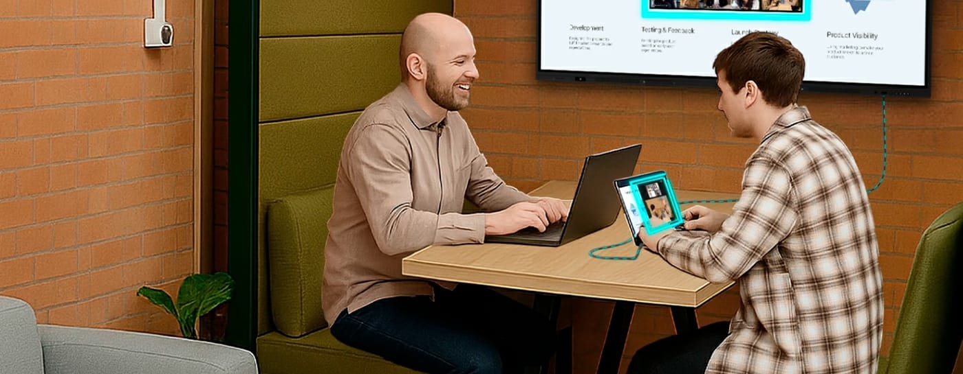Dwie osoby przy stole w huddle roomie prezentują materiał na monitorze interaktywnym iiyama ProLite T5529AS